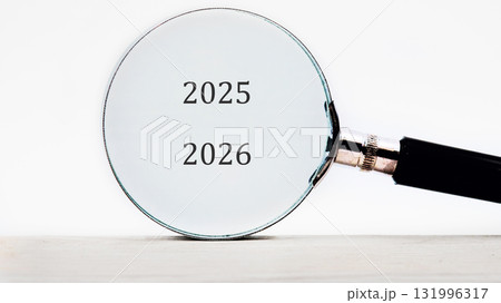 A magnifying glass enlarges the numbers 2025 and 2026 against a plain background. Focus is on the next two years. It suggests planning A magnifying glass enlarges the numbers 2025 and 2026 against a plain background. Focus is on the next two years. It suggests planning 131996317