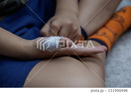 The child has a cut wound covered with a bandage The child has a cut wound covered with a bandage 131998496