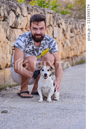 Man grooming Jack Russell Terrier outdoors brushing coat to reduce shedding Man grooming Jack Russell Terrier outdoors brushing coat to reduce shedding 131999374