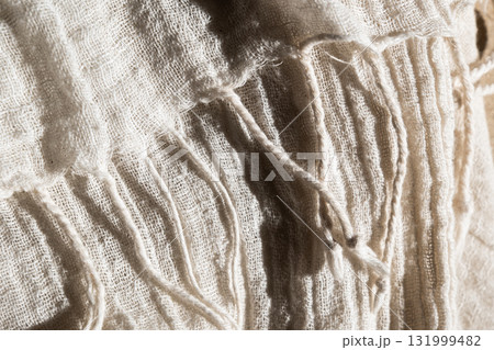 Close-up of soft, light-colored mesh fabric. The texture is visible, showcasing its delicate weave and airy quality. 131999482