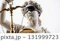 Blindfolded Themis holding golden scales of justice 131999723