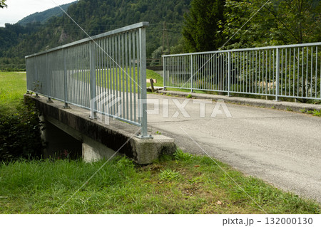 A simple metal bridge over a stream in the forest A simple metal bridge over a stream in the forest 132000130
