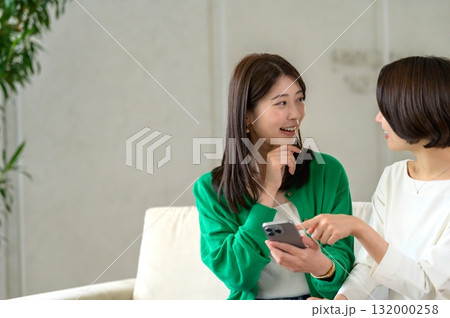 ソファに座って会話をする女性 132000258