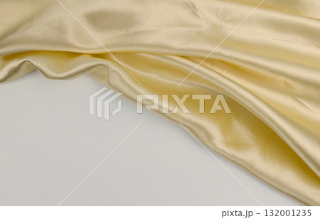 Golden fabric lies softly, highlighting its texture 132001235
