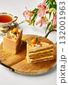 Two slices of orange cake with tea and flowers creating a cozy atmosphere 132001963