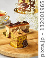 Delicious modern cakes with gold and chocolate decorations resting on wooden table 132001965