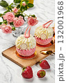 Delicious pink cakes with white cream and strawberries on wooden board 132001968