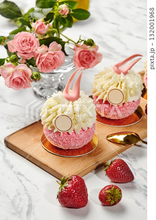 Delicious pink cakes with white cream and strawberries on wooden board Delicious pink cakes with white cream and strawberries on wooden board 132001968