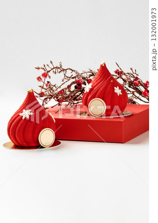 Two red christmas mousse cakes with snowflakes decoration and braun family logo 132001973