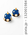 Two blue christmas mousse cakes resembling christmas baubles with golden tops and white snowflakes decoration on golden bases 132001984