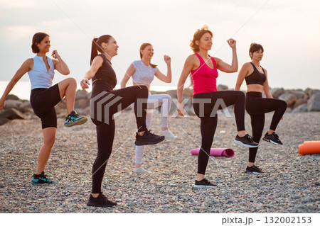 Group of adult athletic Caucasian women are training on beach. Fitness and yoga. Concept of sports and health 132002153