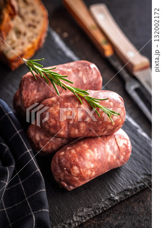 Photo of italian sausage salsiccia on cutting board on black table. 132002172