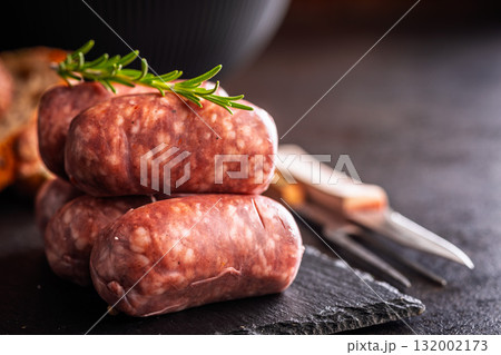 Photo of italian sausage salsiccia on cutting board on black table. Photo of italian sausage salsiccia on cutting board on black table. 132002173