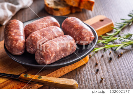 Photo of italian sausage salsiccia on plate on wooden table. 132002177