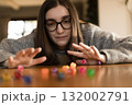 Woman placing a die on top of a tall stack of dice. Concept of focus success and challenge. 132002791
