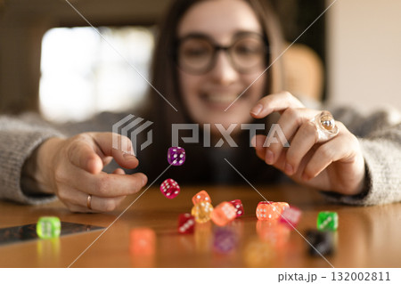 Woman stacking dice in a straight column on a table. Concentration and precision concept. 132002811