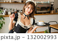メイド服のウェイトレスがカフェラテを笑顔で運んでくる 132002993