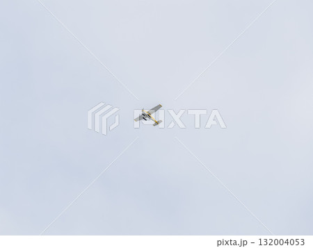 Small ultralight airplane with overhead wing and single propeller flying in sunset sky. Small ultralight airplane with overhead wing and single propeller flying in sunset sky. 132004053