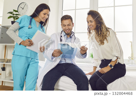 Doctor and nurse looking to medical test results and prescribe treatment to patient in clinic. 132004468