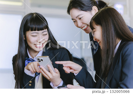 教室でクラスメイトとスマホを見ながら話す女子高生 教室でクラスメイトとスマホを見ながら話す女子高生 132005066