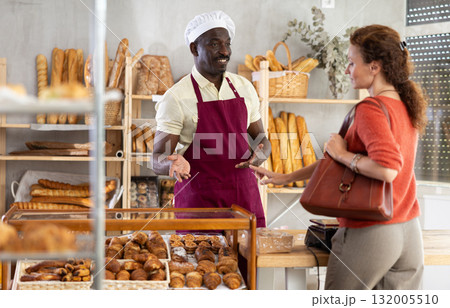 European woman visited bakery, communicates with African male seller European woman visited bakery, communicates with African male seller 132005510