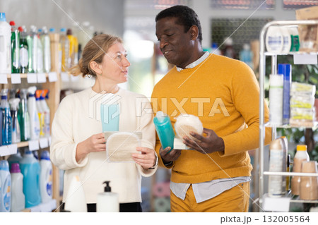 During shopping, African male client with wife advised and choose shampoo, shower gel, bast wisp During shopping, African male client with wife advised and choose shampoo, shower gel, bast wisp 132005564