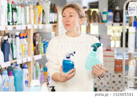 Adult woman chooses cleaning spray in store 132005581