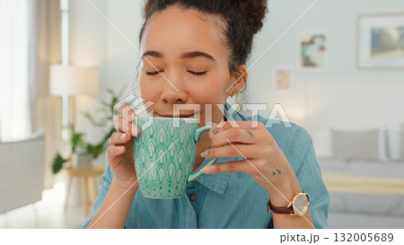Home, relax and woman with coffee, morning and calm with peace, wellness and start the day in a living room. Happy person, girl and lady with tea, espresso and smelling with aroma and cappuccino 132005689