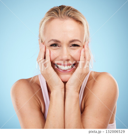 Beauty, woman and face smile in studio for skincare, dermatology and wellness cosmetics on blue background. Happy female model, portrait and excited for aesthetic, self love and laser transformation 132006529