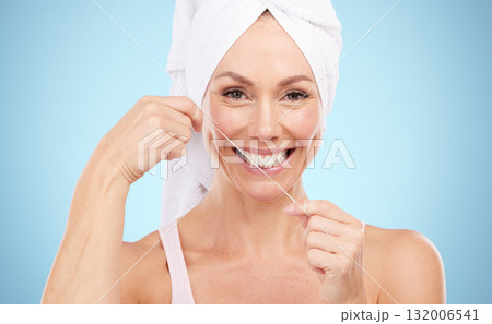 Floss, teeth and portrait of woman in studio for beauty, healthy dental wellness and blue background. Happy female model, tooth flossing and cleaning mouth for face, fresh breath and oral maintenance Floss, teeth and portrait of woman in studio for beauty, healthy dental wellness and blue background. Happy female model, tooth flossing and cleaning mouth for face, fresh breath and oral maintenance 132006541
