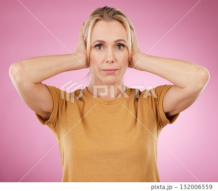 Stress, loud and portrait of a woman with a problem isolated on a pink background in a studio. Sound, frustrated and mature person covering and blocking ears from noise for silence on a backdrop 132006559
