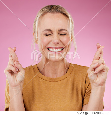 Woman, fingers crossed and hope in studio, pink background and smile face. Female model wish for luck with hands of bonus, promotion and winning giveaway for emoji sign, competition prize and lottery Woman, fingers crossed and hope in studio, pink background and smile face. Female model wish for luck with hands of bonus, promotion and winning giveaway for emoji sign, competition prize and lottery 132006580
