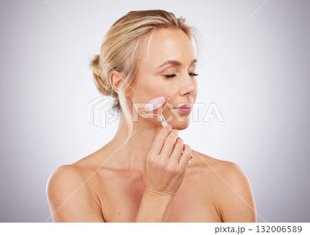 Beauty, face roller and woman doing massage in studio with dermatology and cosmetic tools. Mature aesthetic model skin care facial product for health, wellness and natural skin or anti aging glow 132006589