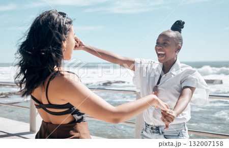Friends, holding hands and women dance at beach, having fun and laughing together outdoors. Comic, freedom and girls laugh at funny comedy or joke, dancing and enjoying time at promenade seashore. Friends, holding hands and women dance at beach, having fun and laughing together outdoors. Comic, freedom and girls laugh at funny comedy or joke, dancing and enjoying time at promenade seashore. 132007158