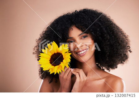 Black woman, studio portrait and sunflower with smile, beauty and cosmetic wellness by beige background. African gen z model, flower and spring aesthetic with happiness, makeup and natural makeup Black woman, studio portrait and sunflower with smile, beauty and cosmetic wellness by beige background. African gen z model, flower and spring aesthetic with happiness, makeup and natural makeup 132007415
