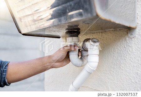 Plumber, water pipes and man hands for maintenance, renovation and builder service. Closeup handyman, pipeline and plumbing for leak, broken drainage and installation of faucet system, sink or repair Plumber, water pipes and man hands for maintenance, renovation and builder service. Closeup handyman, pipeline and plumbing for leak, broken drainage and installation of faucet system, sink or repair 132007537