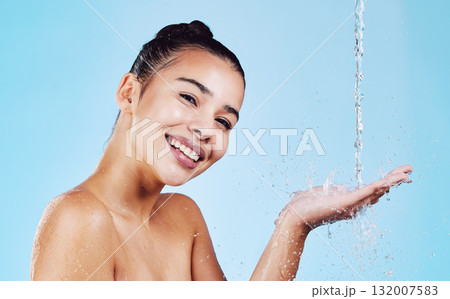 Water drops, skincare and portrait of woman with smile for health, wellness and hygiene with cleaning routine. Shower, cosmetic beauty and happy girl in skin care for hands on blue studio background. Water drops, skincare and portrait of woman with smile for health, wellness and hygiene with cleaning routine. Shower, cosmetic beauty and happy girl in skin care for hands on blue studio background. 132007583