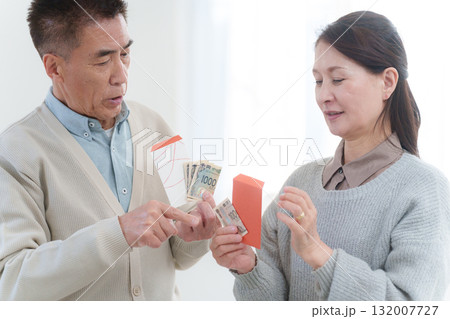 孫にお年玉をあげる祖父母 132007727