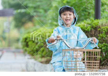 雨の日にレインコートを着て自転車に乗る子供 132007736