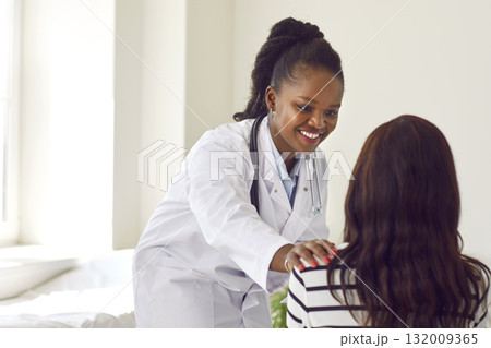 African american smiling doctor, nurse, professional female physician consulting young girl patient African american smiling doctor, nurse, professional female physician consulting young girl patient 132009365