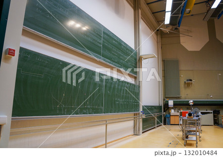 難しそうな数式やグラフが書かれた大きな黒板が設置された教室 難しそうな数式やグラフが書かれた大きな黒板が設置された教室 132010484