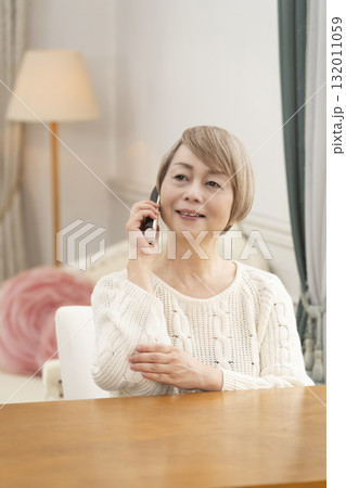 家の電話で楽しくおしゃべりするシニア女性 家の電話で楽しくおしゃべりするシニア女性 132011059