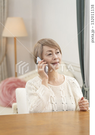 スマートホンで楽しくおしゃべりしたり検索したりするシニア女性 132011138