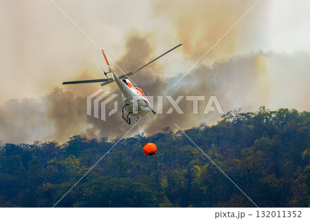 Fire fighting helicopter carry watethar bucket to extinguish the forest fire. 132011352