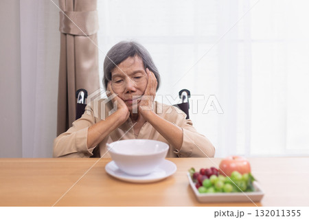 Lonely senior asian woman bored with food. 132011355