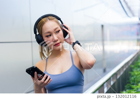 Sport woman listening music, doing exercise workout outdoors, fit people embrace active lifestyle in urban setting, modern sport provides health benefits. Sport woman listening music, doing exercise workout outdoors, fit people embrace active lifestyle in urban setting, modern sport provides health benefits. 132012116