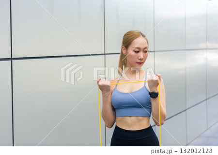 Exercise woman sport workout, fit person does outdoor stretch exercise with resistance band, achieving strength and health goals for active lifestyle. 132012128