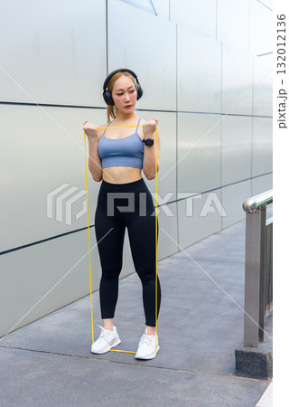 Sport woman outdoor exercise, fit people performing dynamic workout, stretching body with resistance band, engaging in physical exercise routine for health. 132012136