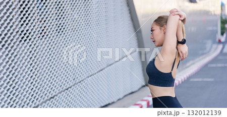 Fit woman performs sport workout outdoor, body needs stretch exercise, people active for fitness, urban setting provides full stretch routine. Fit woman performs sport workout outdoor, body needs stretch exercise, people active for fitness, urban setting provides full stretch routine. 132012139