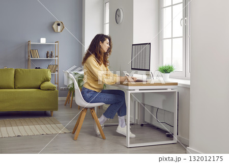 Young business woman accountant working on a laptop with tables at office. 132012175